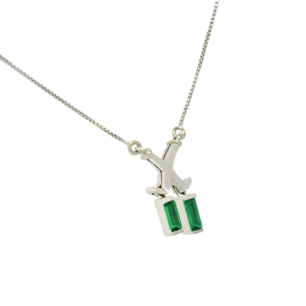 This emerald necklace has an X shape in solid 18K white gold where the two emeralds droop freely at the bottom part of the center of this gorgeous necklace