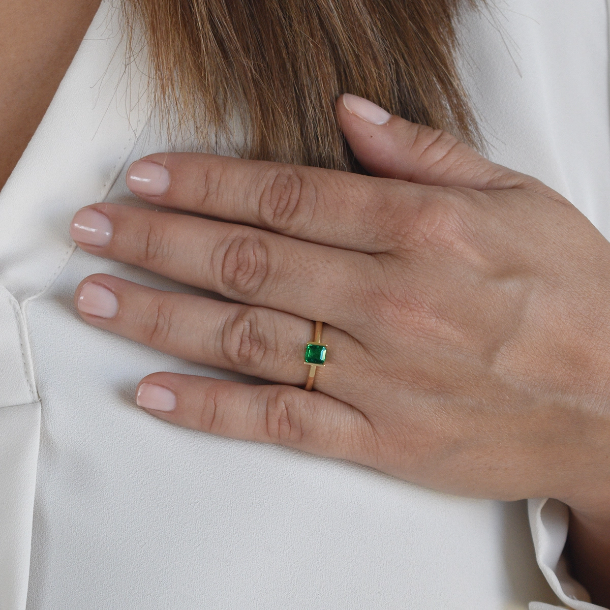 The ring's simple design focuses entirely on the emerald, highlighting its uniqueness and elegance. The solo-stone setting lets the emerald's natural characteristics shine